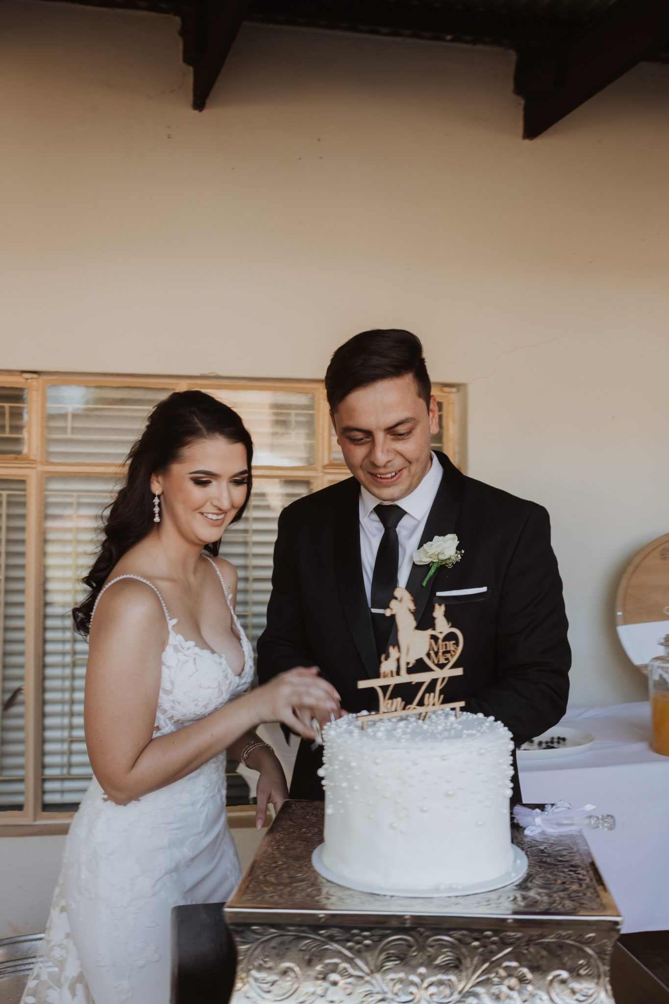 Couple holding Pretzel's graduation certificate in kitchen